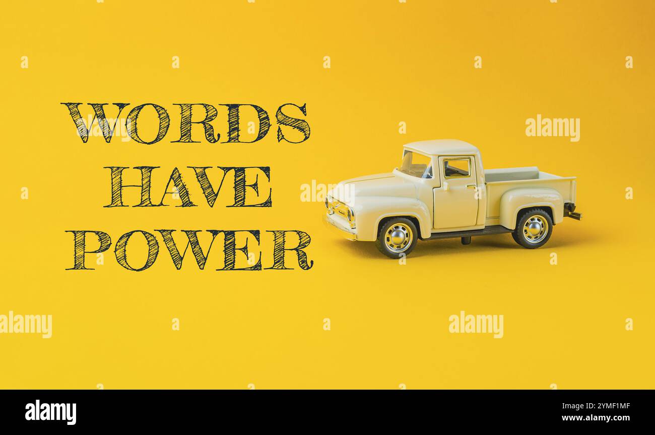 Le camion jouet est sur un fond jaune avec les mots Have POWER écrits en dessous Banque D'Images