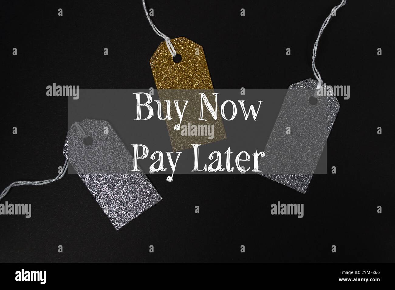 Trois étiquettes avec des paillettes dorées et argentées suspendues à une ficelle. Les tags disent acheter maintenant payer plus tard Banque D'Images