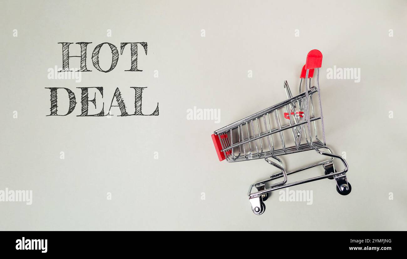 Panier avec le mot HOT DEAL écrit dessus. Le chariot est en métal et a une poignée rouge Banque D'Images