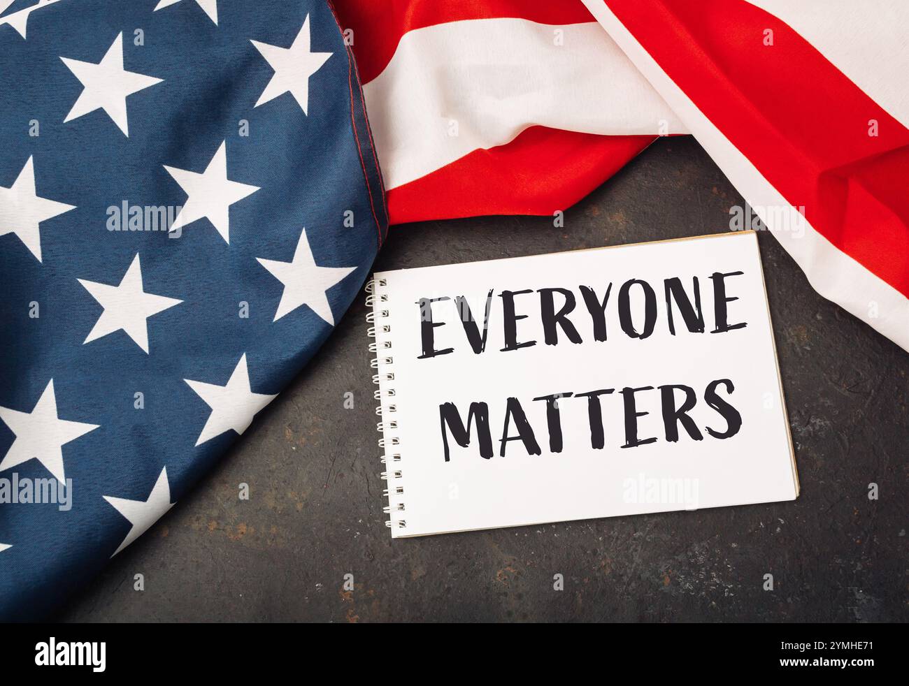Morceau de papier blanc avec les mots Everybody Matters écrit dessus. Le papier est placé au-dessus d'un drapeau américain rouge et blanc Banque D'Images
