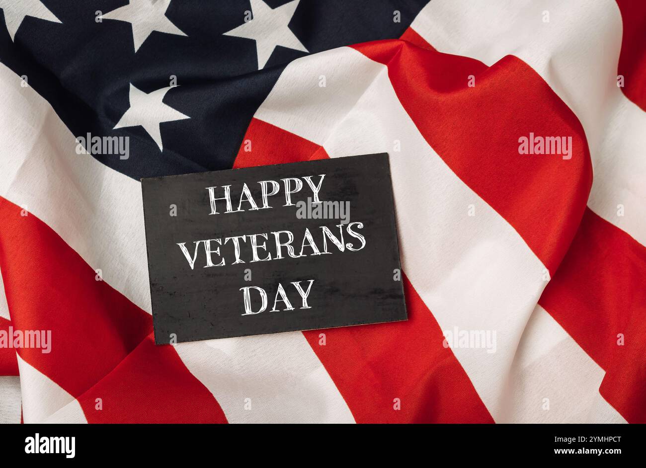 Un panneau noir avec les mots Happy Veterans Day est placé au-dessus d'un drapeau américain rouge et blanc Banque D'Images