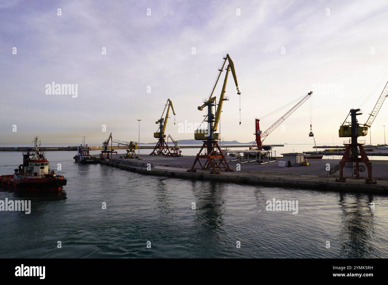 Grues rétro-éclairées dans la lumière tôt le matin dans le port de Kusadasi, Turquie Banque D'Images