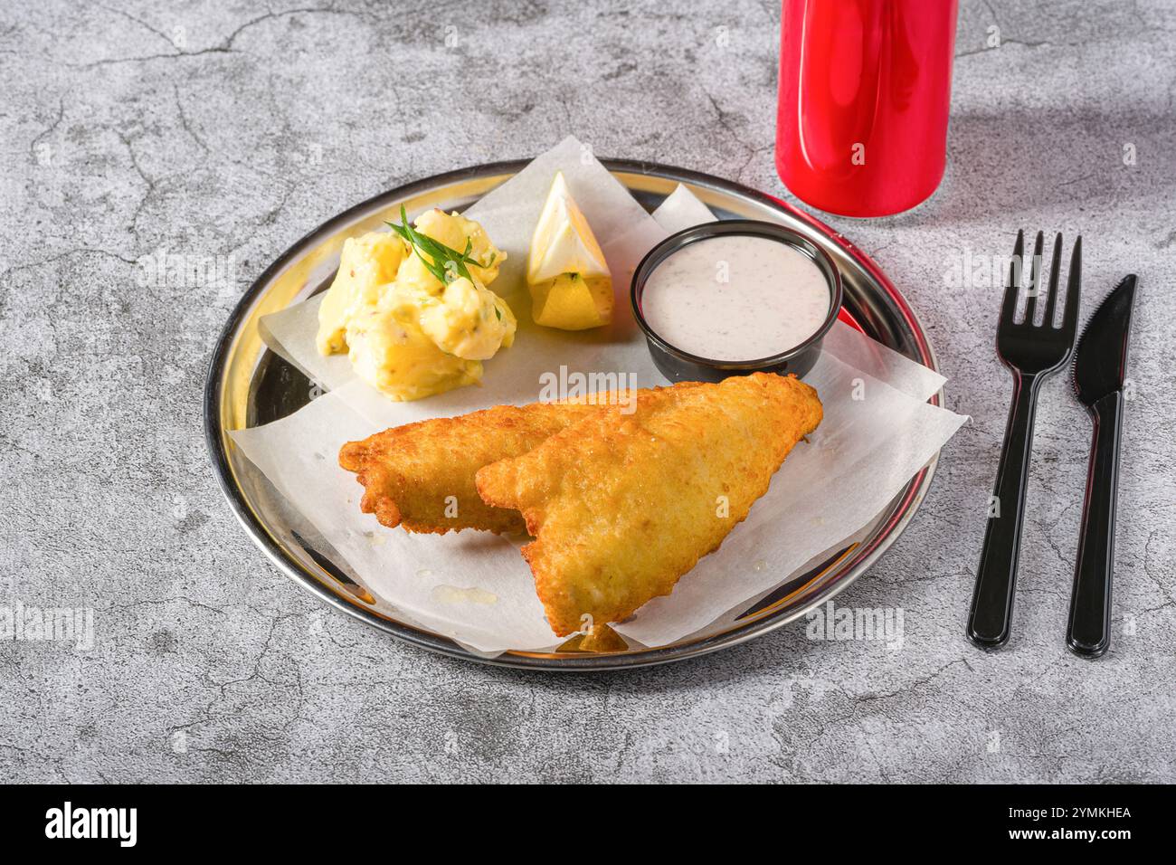 Filet de poisson enrobé frit avec salade de pommes de terre sur table en pierre Banque D'Images