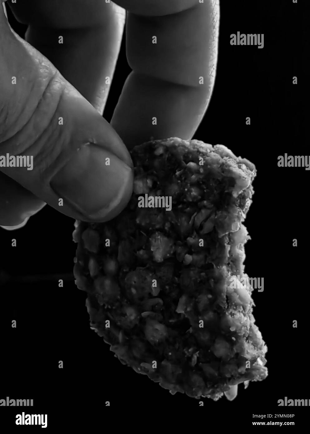 Tu veux mordre ? Biscuit croquant sur fond sombre Banque D'Images