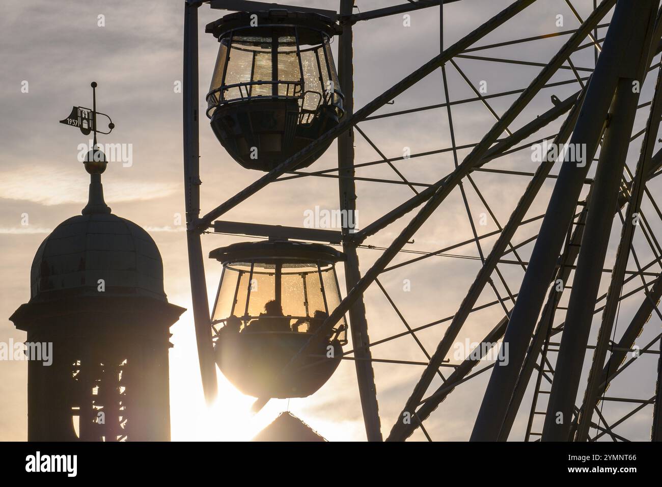 22 novembre 2024, Saxe-Anhalt, Magdebourg : les visiteurs du marché de Noël de Magdebourg prennent la grande roue au coucher du soleil. Les stands et manèges du marché de Noël de la capitale de l'État de Saxe-Anhalt ont ouvert dans l'après-midi. Cependant, l'ouverture officielle n'est prévue qu'après le dimanche des morts le 25 novembre 2024, lorsque les lumières du sapin de Noël seront également allumées. Photo : Klaus-Dietmar Gabbert/dpa Banque D'Images