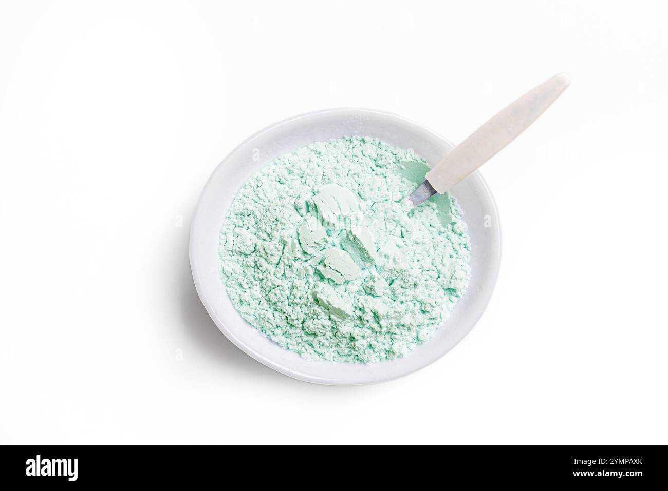 Poudre d'argile verte naturelle dans un bol avec cuillère isolé sur fond blanc, élément de design. Argile comestible. Poudre d'alginate. Banque D'Images
