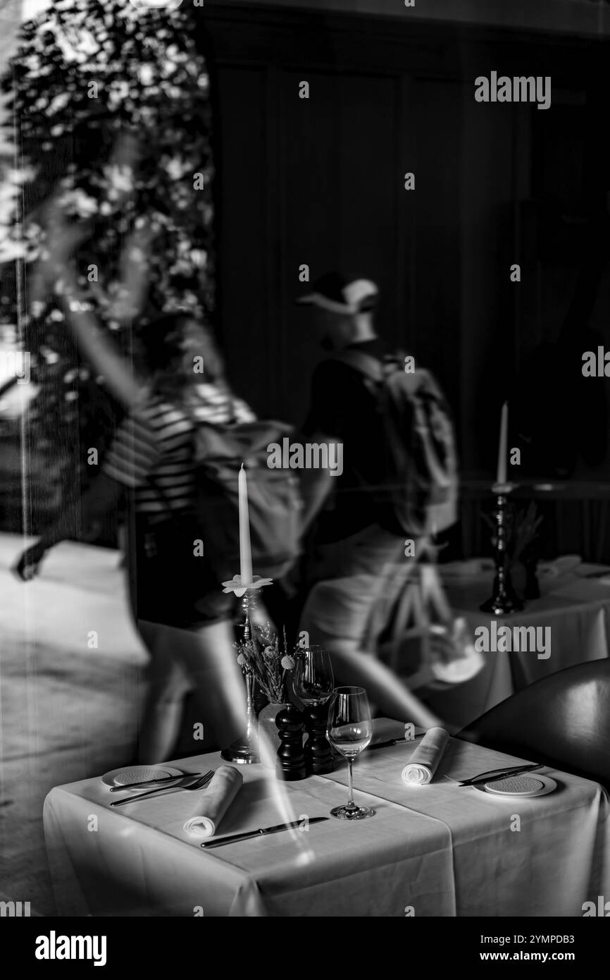 Beau restaurant avec réflexion de fenêtre sur la table et la chaise et les gens marchant dans la rue dans la ville de Berne, Canton Berne, Suisse. Banque D'Images