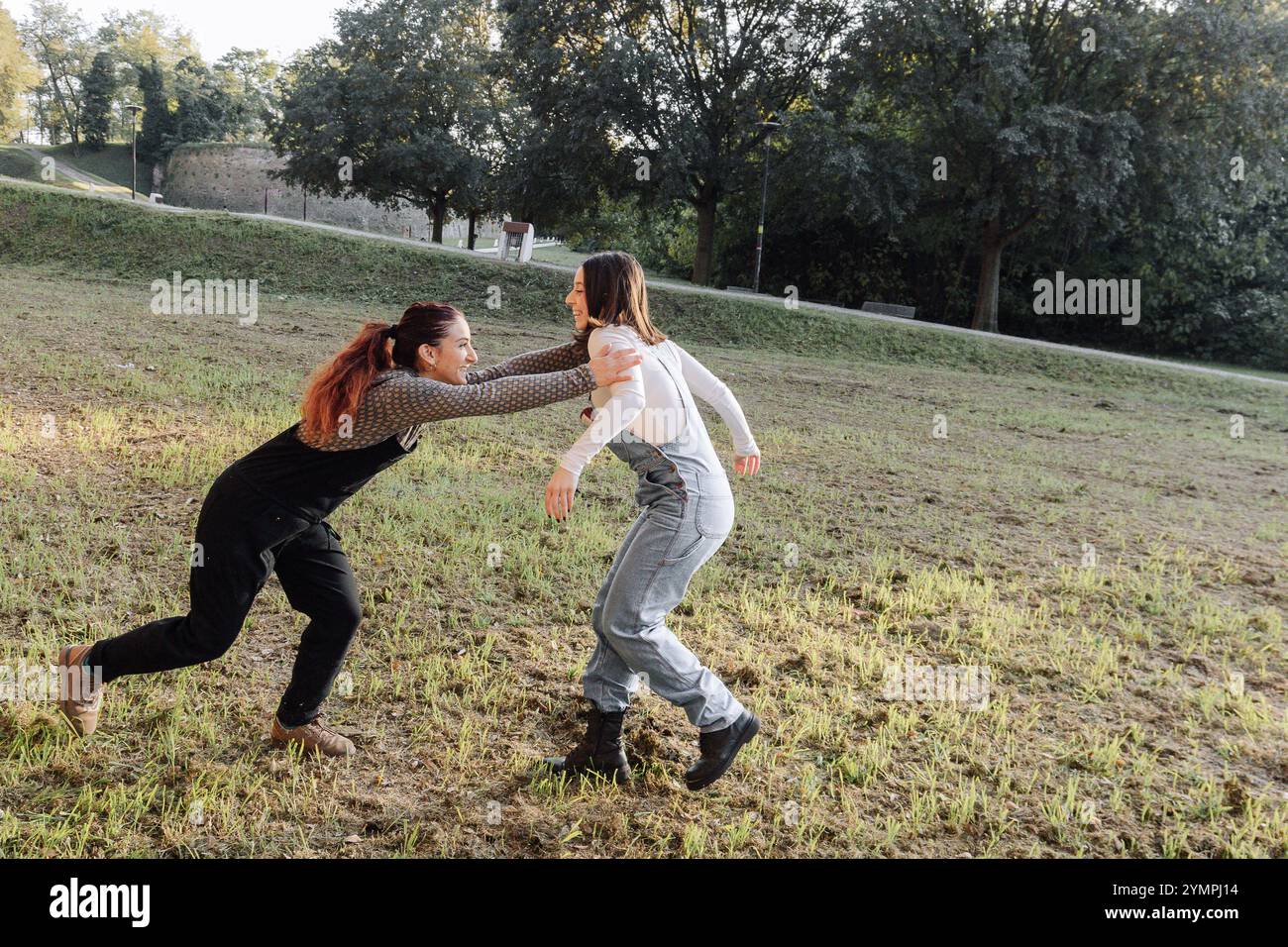 Deux amies jouissant d'un moment ludique dans un parc, courant et riant ensemble Banque D'Images