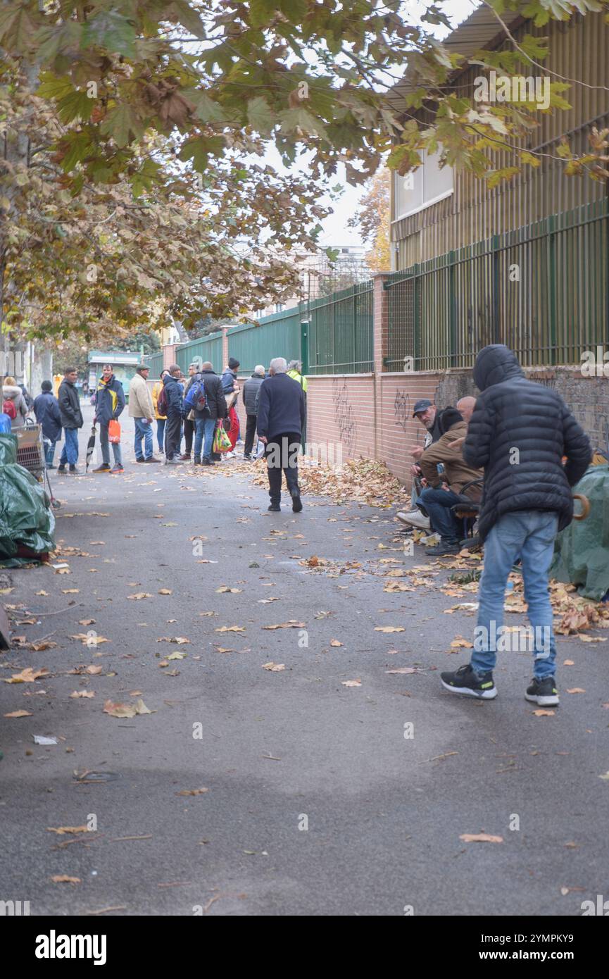 Rome, Italie. 22 novembre 2024. Des gens faisant la queue pour entrer dans l'une des soupes populaires de Caritas à Rome. De 2022 à 2023, l’accès aux centres d’écoute diocésains de Caritas a augmenté de 22% selon le rapport Caritas sur la pauvreté à Rome présenté ce matin. Le rapport met en évidence des inégalités de plus en plus marquées, dont la cause, souligne-t-on, est l’absence de politiques pour le logement, les bâtiments scolaires, les soins de santé, les politiques actives du travail, malgré le fait que Rome, selon les données macroéconomiques, continue d’être une ville dans laquelle l’économie continue de croître. Au cours de l'année 2023, dans les divers services Banque D'Images