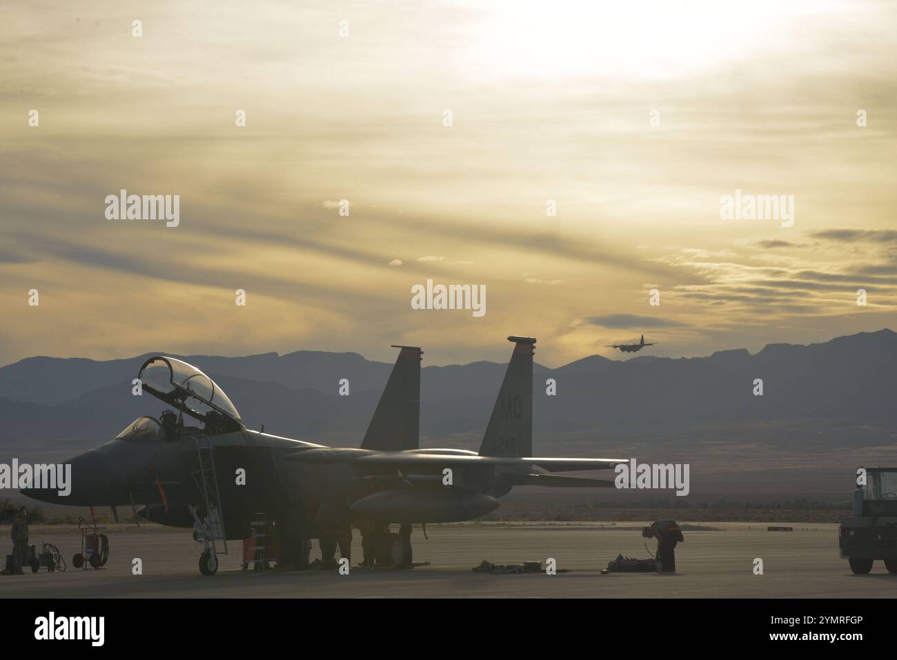 Un F-15E Strike Eagle de l'US Air Force, affecté au 389th Fighter Squadron, est assis sur la ligne de vol en tant que C-130J Super Hercules, affecté à la 19th Airlift Wing, atterrit à Historic Wendover Airfield, Utah, Oct. 22, 2024. Des aviateurs de la base aérienne de Mountain Home ont mené l'exercice RAGING GUNFIGHTER 25-1, un exercice de préparation opérationnelle de routine, à divers endroits de la sous-région de Mountain West aux États-Unis, à partir du 21 octobre et a duré environ 10 jours. Des exercices tels que RAGING GUNFIGHTER préparent le personnel du Air combat Command avec des outils, des tactiques et des procédures pour resperon Banque D'Images