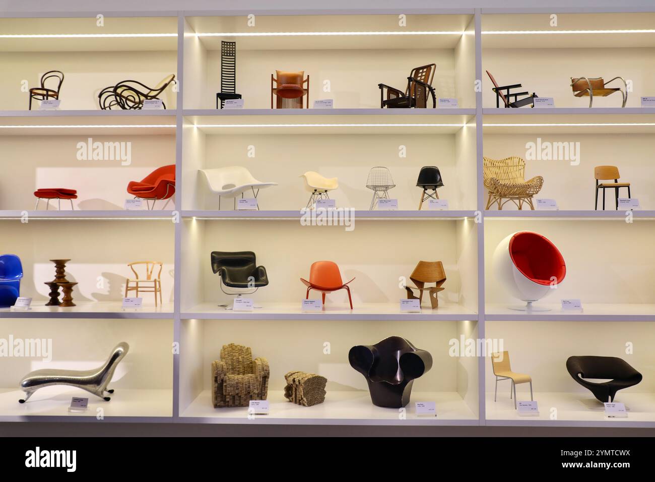 Weil am Rhein, Bade-Wurtemberg, Allemagne. 3 décembre 2022. Des miniatures de chaises design exposées dans la vitrine du Vitra Museum à Weil am Rhein retracent l'histoire du design. De gauche à droite sur l'étagère supérieure : Stuhl no 14 de Michael Thonet & sons, Schaukelsessel no 9 de J. & J. Kohn, Hill House 1 de Charles Rennie Mackintosh, Barrel chair de Frank Lloyd Wright, Sitzmaschine de Josef Hoffmann, Rood blauwe stoel de Gerrit Rietveld et MR 20 de Mies van der Rohe. Sur la deuxième étagère la plus haute : Womb chair & Ottoman par Eero Saarinen, la chaise, RAR et DSW par Charles & Ray Eames, GA Banque D'Images