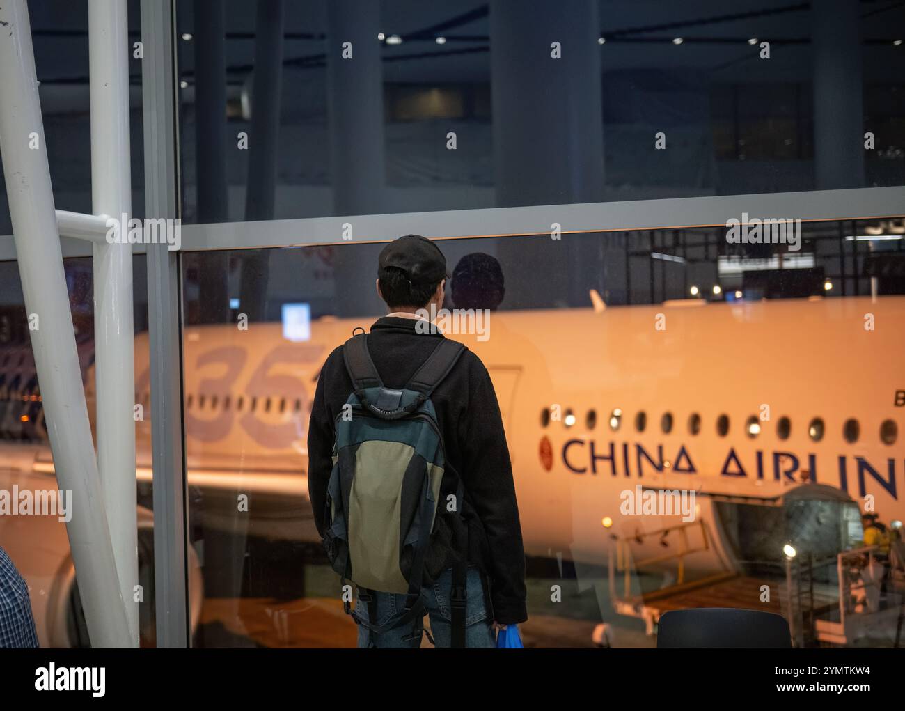 Auckland, Nouvelle-Zélande - 22 octobre 2024 : homme regardant l'avion de China Airlines à l'aéroport international d'Auckland. Banque D'Images