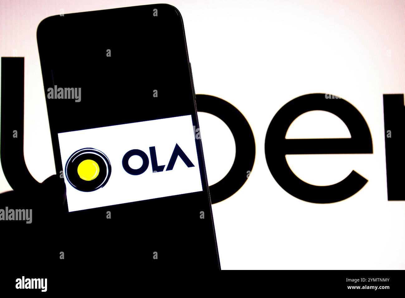 Inde. 19 novembre 2024. Dans cette illustration photo, un logo OLA est affiché sur un smartphone avec un logo UBER en arrière-plan. (Photo par Avishek Das/SOPA images/SIPA USA) *** strictement à des fins d'actualités éditoriales *** crédit : SIPA USA/Alamy Live News Banque D'Images