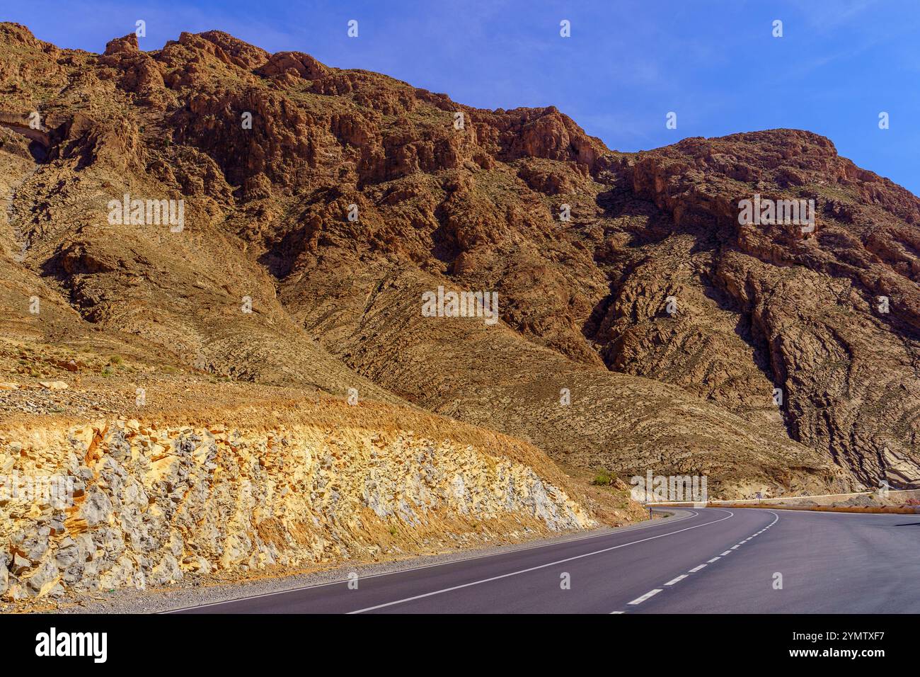 Vue sur la route et la formation rocheuse dans la vallée du Ziz, les montagnes du moyen Atlas, Maroc Banque D'Images
