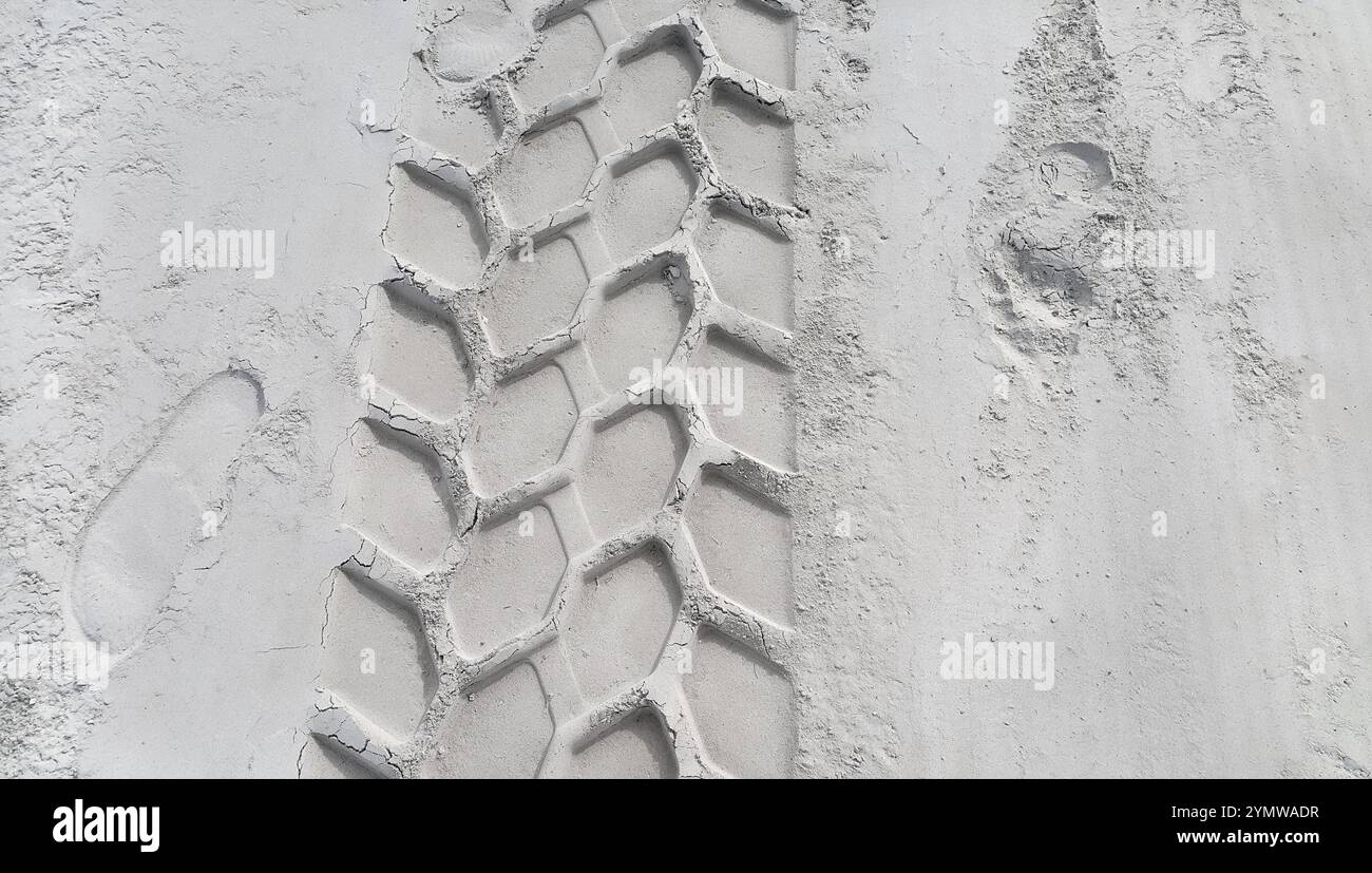 Piste de roue et empreintes de pas sur la plage de sable Banque D'Images