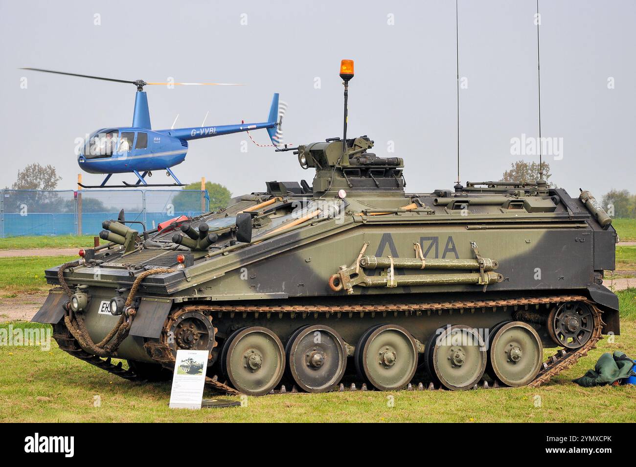 Véhicule blindé CVRT Spartan Alvis FV103 de l'armée britannique exposé, avec hélicoptère Robinson R44 volant. Événement à l'aéroport de Southend Banque D'Images