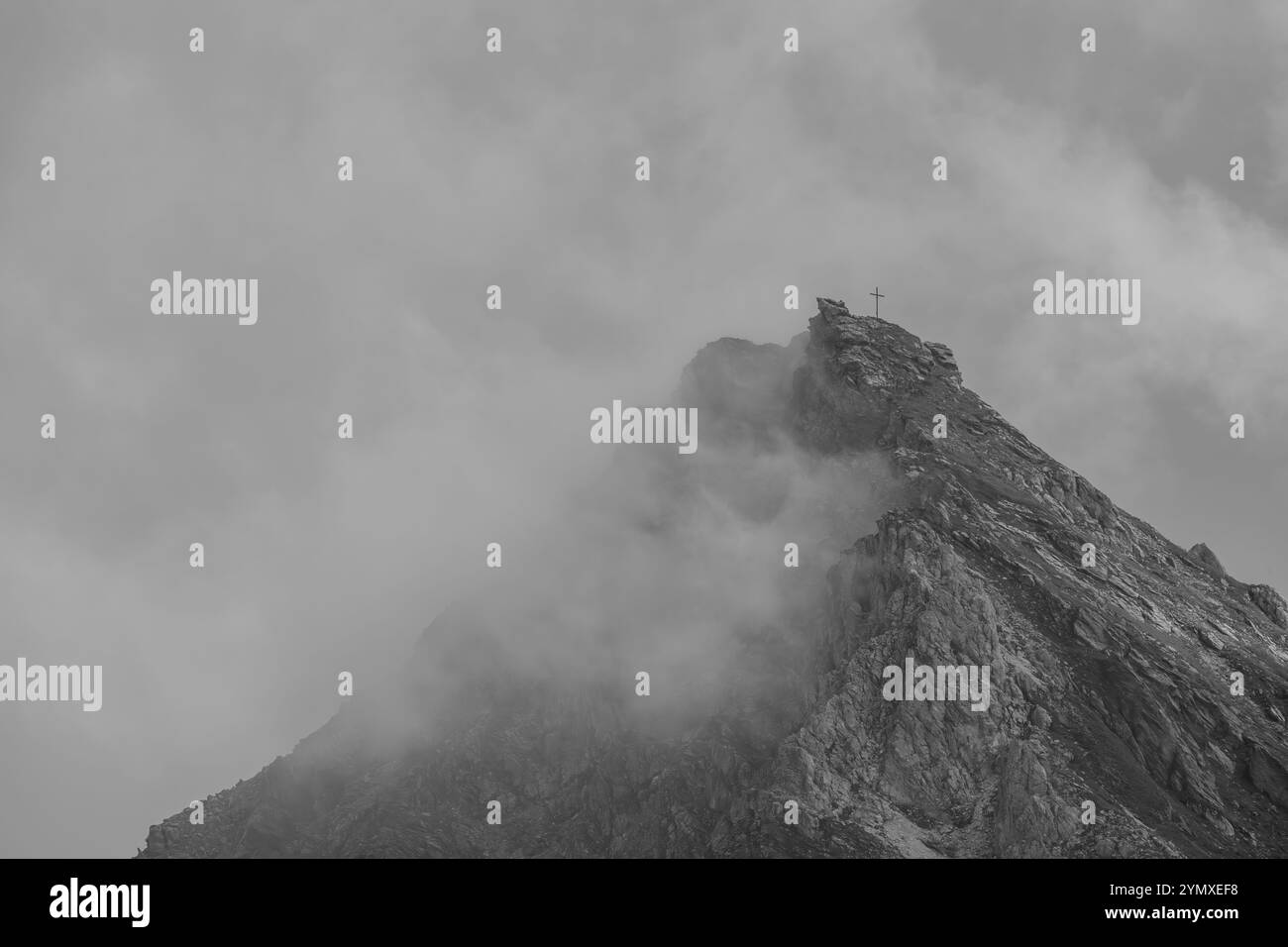 Une croix sommitale avec brouillard dans les Alpes autrichiennes Banque D'Images