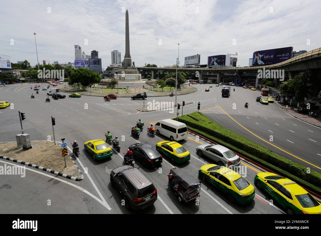 Bangkok, Thaïlande - 25 juin 2023 : les conducteurs naviguent près du monument emblématique du Victory Monument. Banque D'Images