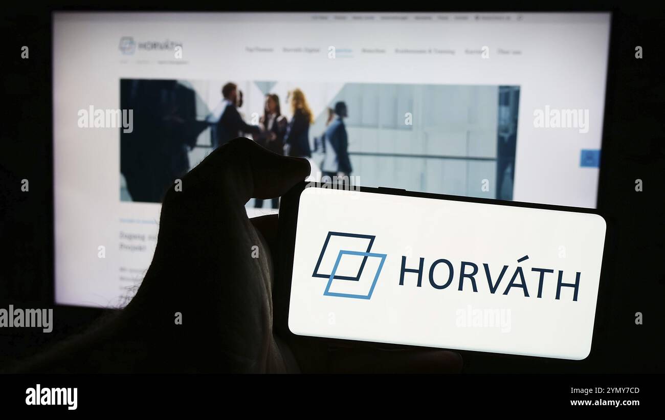 Stuttgart, Allemagne, 07-15-2024 : personne tenant un téléphone portable avec le logo de la société allemande de conseil en gestion Horvath AG devant la page web de l'entreprise Banque D'Images
