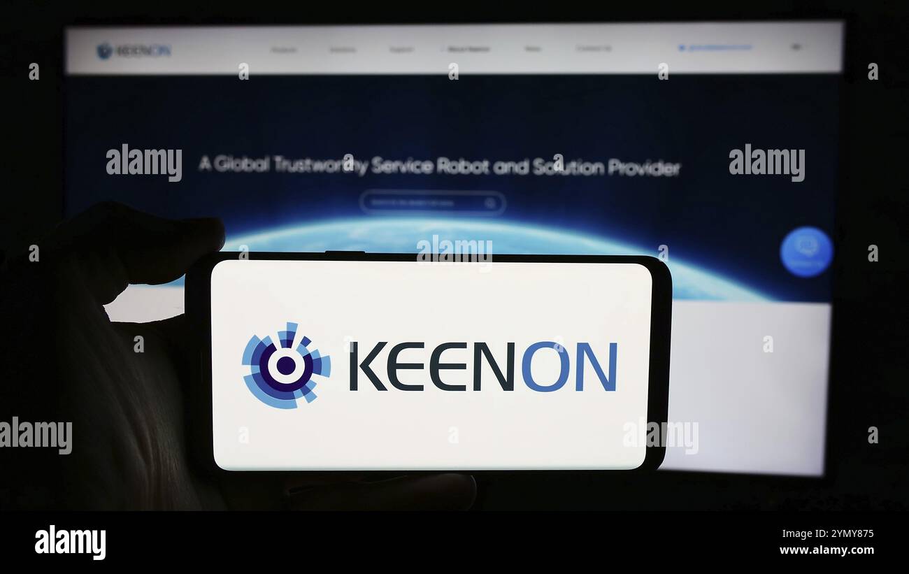 Stuttgart, Allemagne, 05-16-2024 : personne tenant un téléphone portable avec le logo de la société chinoise de robot de service Keenon Robotics Co. Ltd en face de la page Web. Focu Banque D'Images