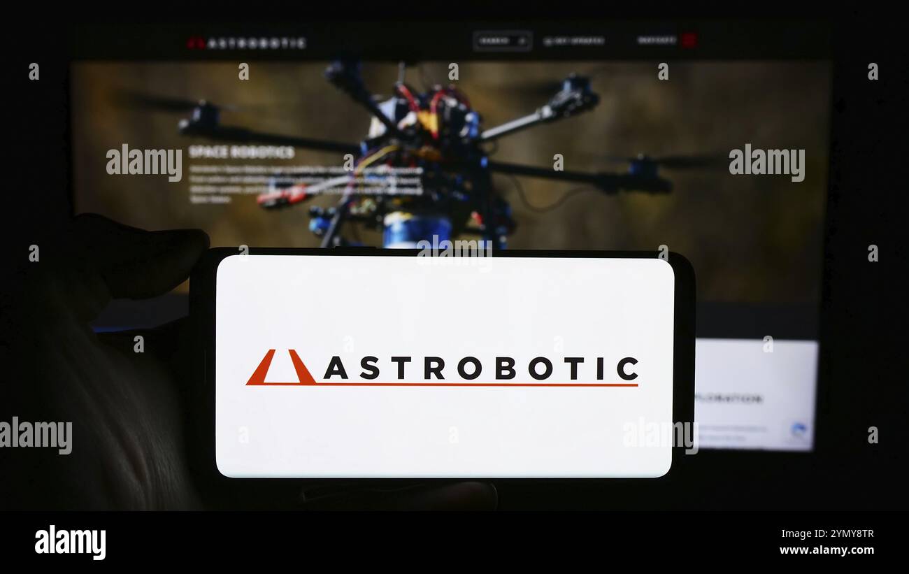 Stuttgart, Allemagne, 03-14-2024 : personne tenant un téléphone portable avec le logo de la société américaine de robotique spatiale Astrobotic Technology Inc devant le webpag d'affaires Banque D'Images
