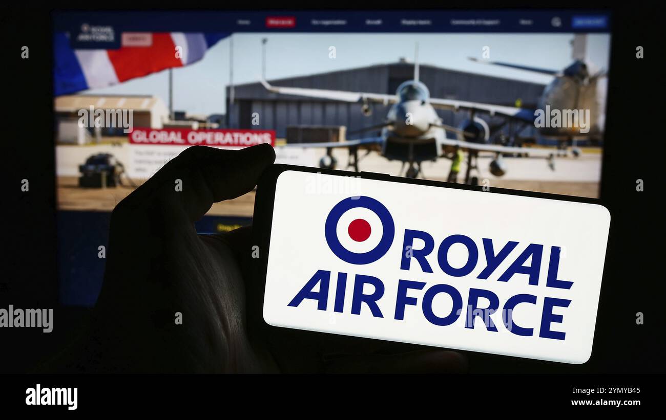 Stuttgart, Allemagne, 03-25-2024, personne tenant un smartphone avec le logo de la Royal Air Force (RAF) de la force aérienne et spatiale du Royaume-Uni devant le site web. F Banque D'Images