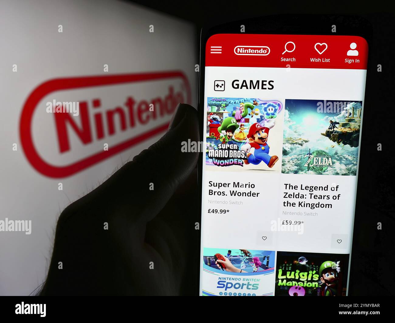 Stuttgart, Allemagne, 07-19-2024 : personne tenant un téléphone portable avec la page Web de la société japonaise de jeux vidéo Nintendo Co. Ltd devant le logo. Concentrez-vous sur cent Banque D'Images