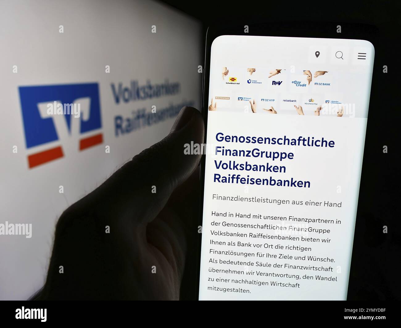 Stuttgart, Allemagne, 07-15-2024 : personne tenant un téléphone portable avec le site web du réseau bancaire allemand Volksbanken Raiffeisenbanken devant le logo. Focus o o Banque D'Images