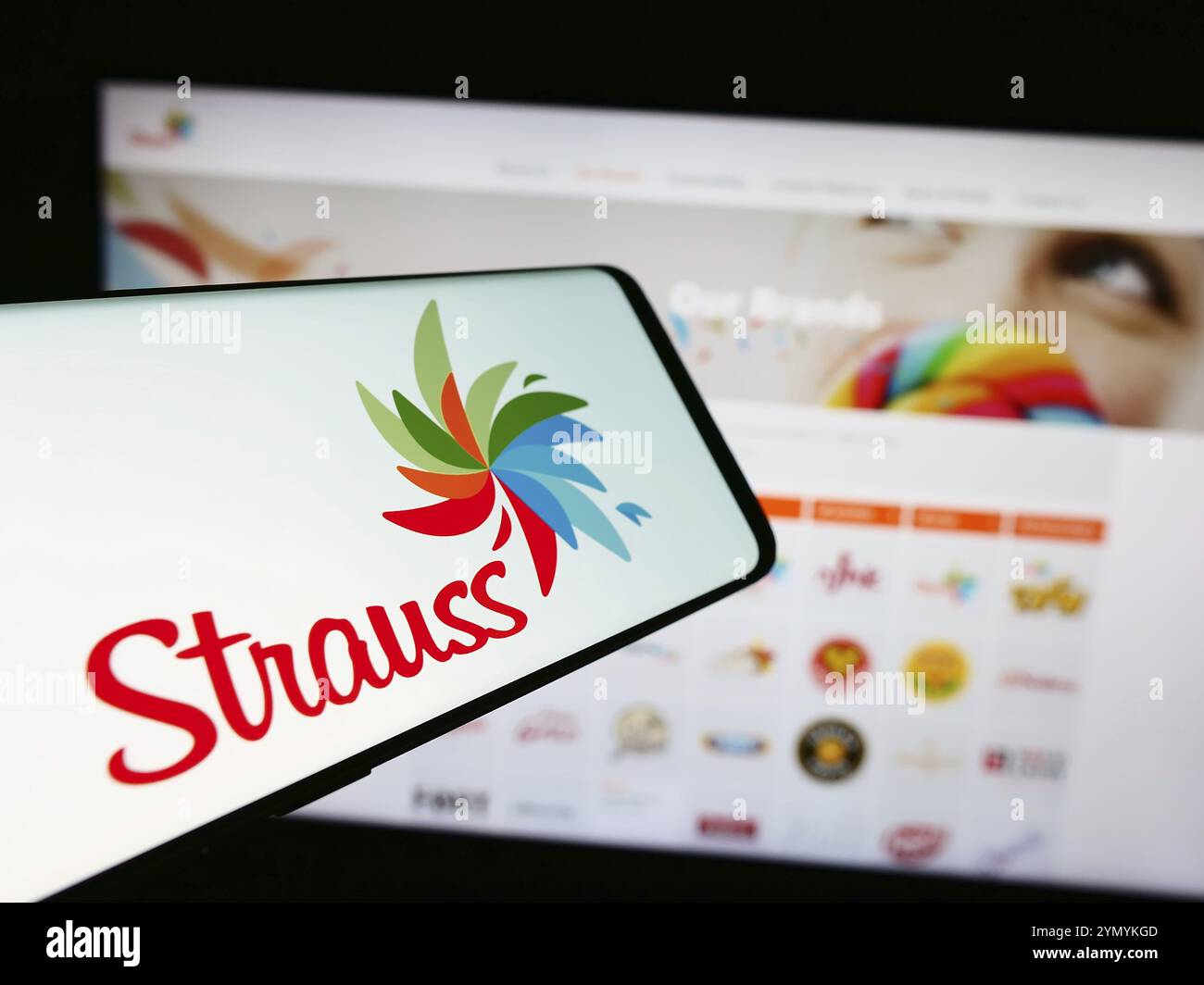 Stuttgart, Allemagne, 07-10-2024 : téléphone portable avec le logo de biens de consommation israéliens Comapny Strauss Group Ltd devant le site Web de l'entreprise. Focus sur le cen Banque D'Images