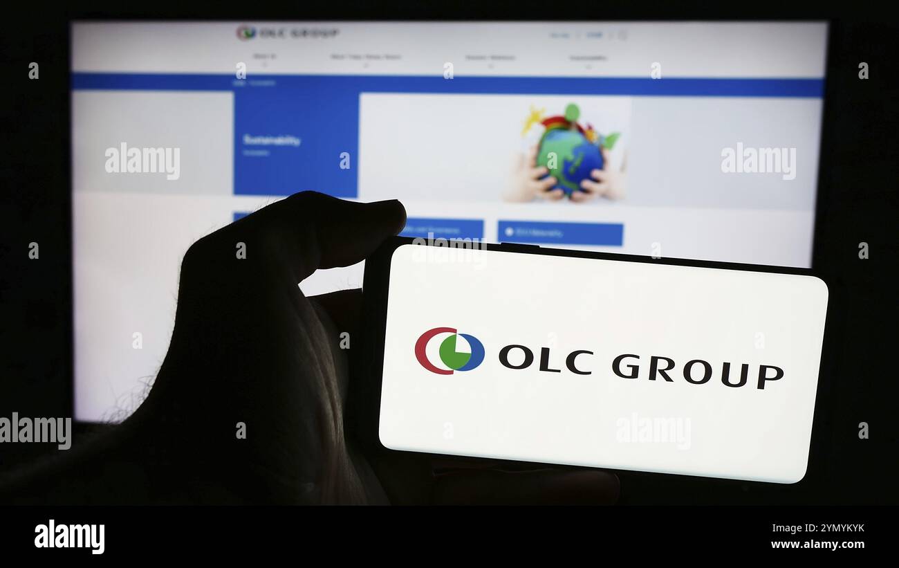 Stuttgart, Allemagne, 07-25-2024, personne tenant un smartphone avec le logo de la société de tourisme japonaise Oriental Land Co. Ltd (OLC) devant le site. Focu Banque D'Images