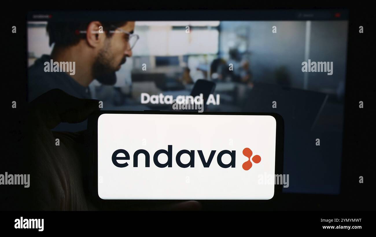 Stuttgart, Allemagne, 04-18-2024 : personne tenant un smartphone avec le logo de la société britannique de logiciels Endava plc en face du site. Concentrez-vous sur l'affichage du téléphone Banque D'Images