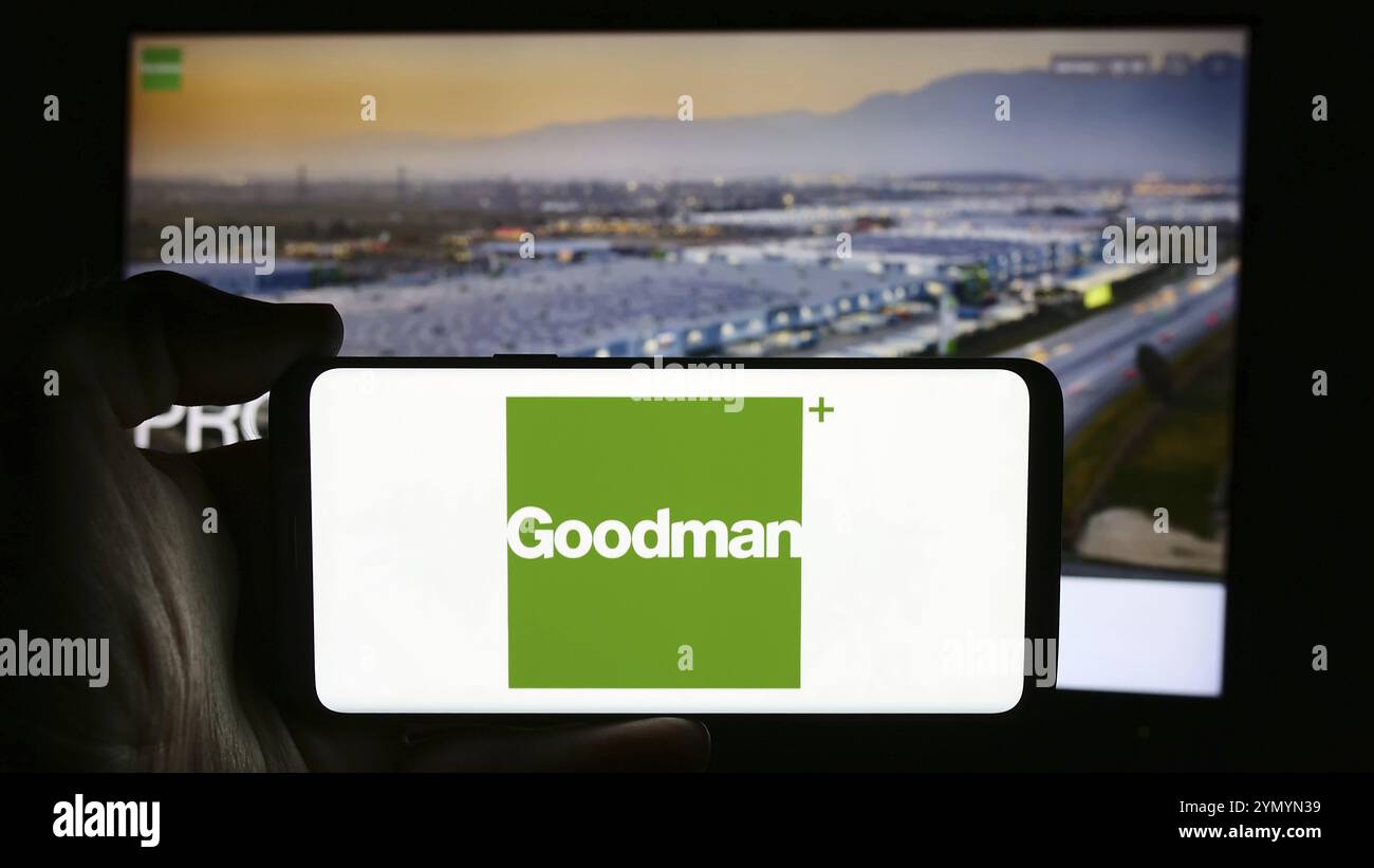 Stuttgart, Allemagne, 07-25-2024, personne tenant un téléphone portable avec le logo de la société immobilière australienne Goodman Group en face de la page web de l'entreprise. Focu Banque D'Images