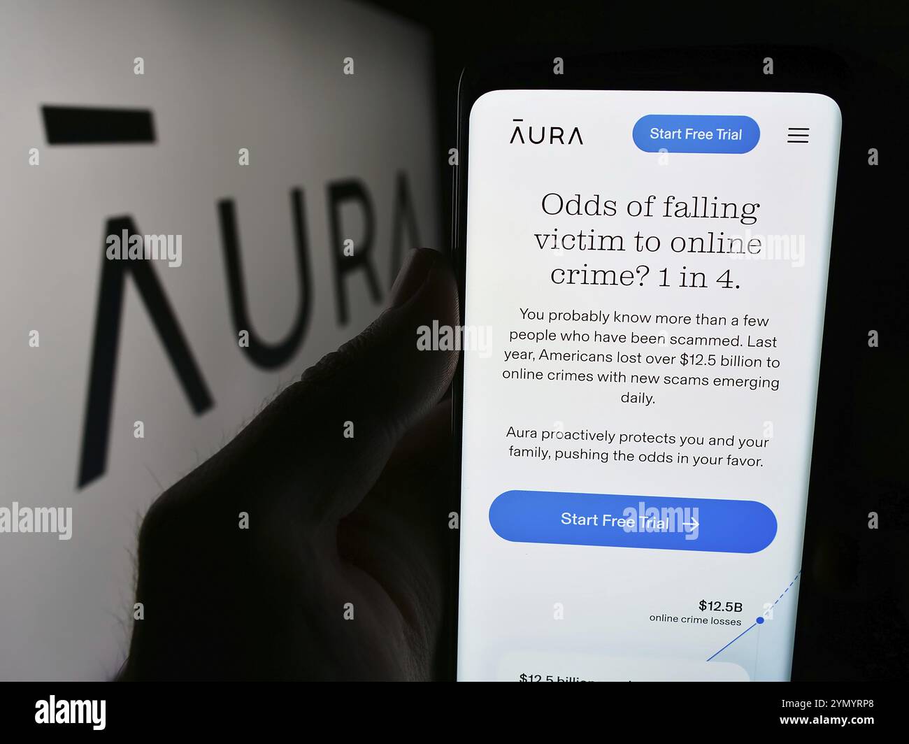 Stuttgart, Allemagne, 07-12-2024 : personne tenant un téléphone portable avec le site Web de la société américaine de logiciels de cybersécurité aura Sub LLC devant le logo. Focus sur le cen Banque D'Images