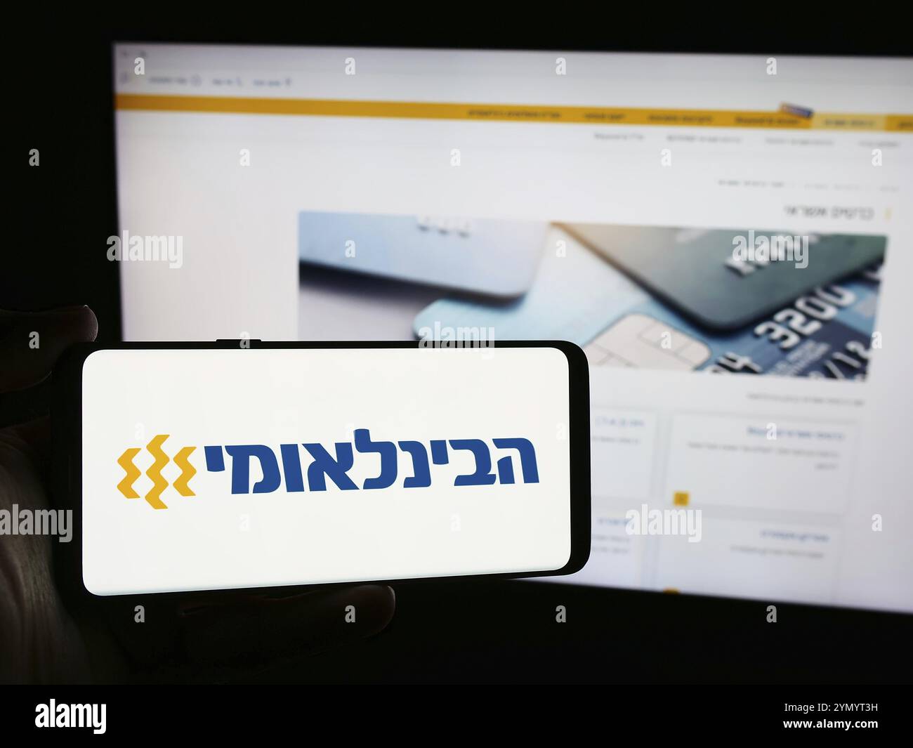 Stuttgart, Allemagne, 07-08-2024 : personne tenant un smartphone avec le logo de la société First International Bank of Israel Ltd (FIBI) devant le site Web. FOC Banque D'Images
