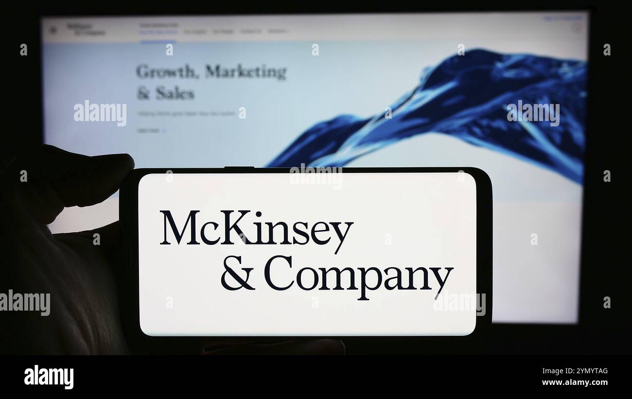Stuttgart, Allemagne, 03-16-2024 : personne tenant un téléphone portable avec le logo de l'entreprise de conseil américaine McKinsey and Company en face de la page Web. Concentrez-vous sur le téléphone Banque D'Images