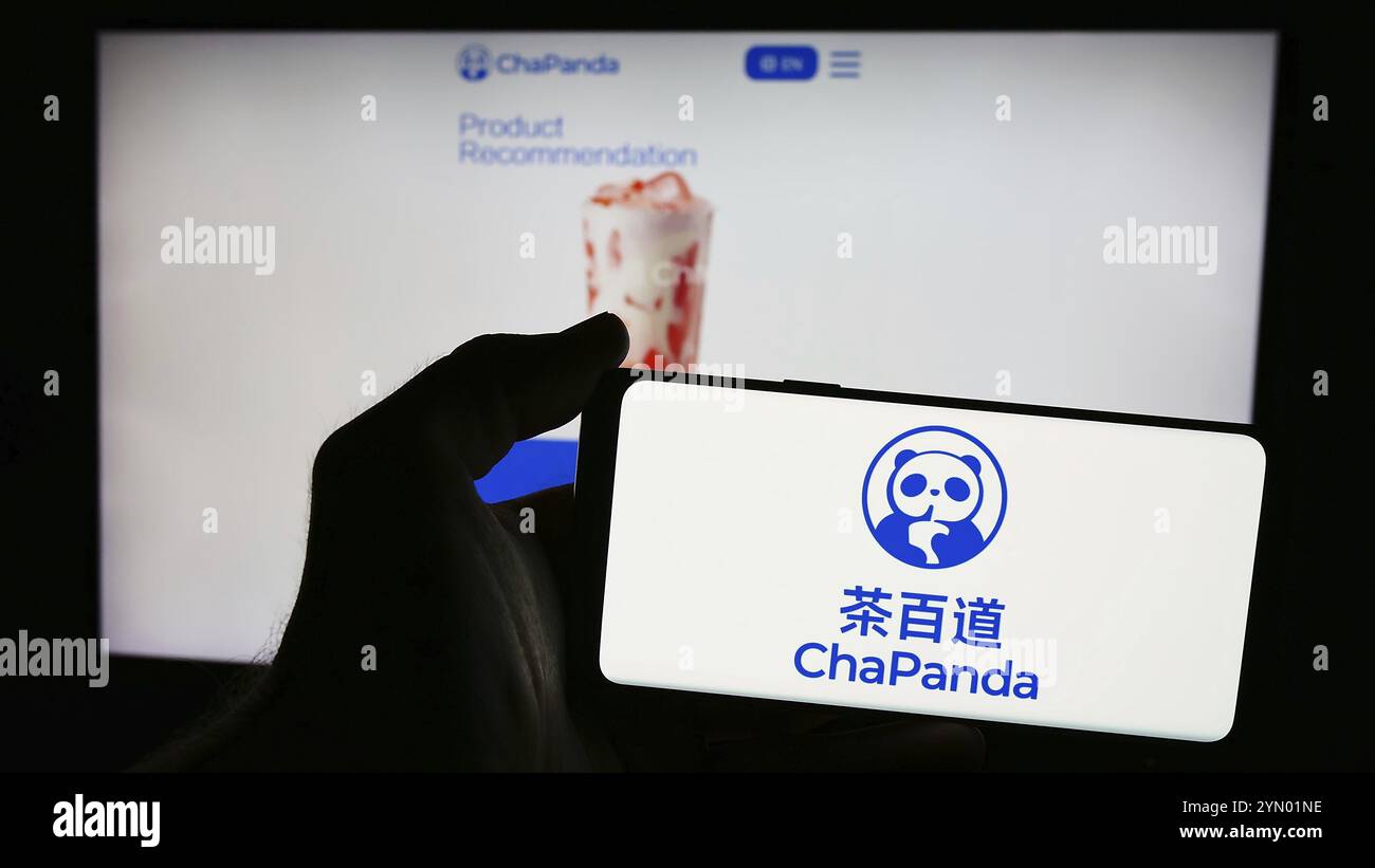 Stuttgart, Allemagne, 07-11-2024 : personne tenant un téléphone portable avec le logo de Chengdu Chabaidao Catering Management Co. Ltd. (ChaPanda) devant le Web pag Banque D'Images