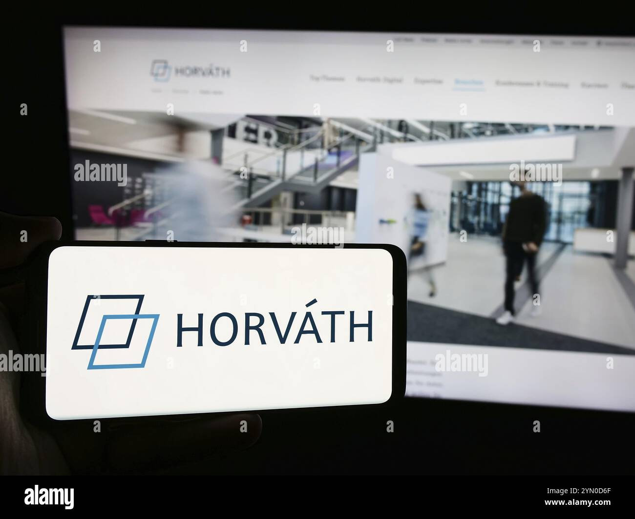 Stuttgart, Allemagne, 07-15-07 2024 : personne tenant un smartphone avec le logo de la société allemande de conseil en gestion Horvath AG devant le site Web. Concentrez-vous sur p. Banque D'Images