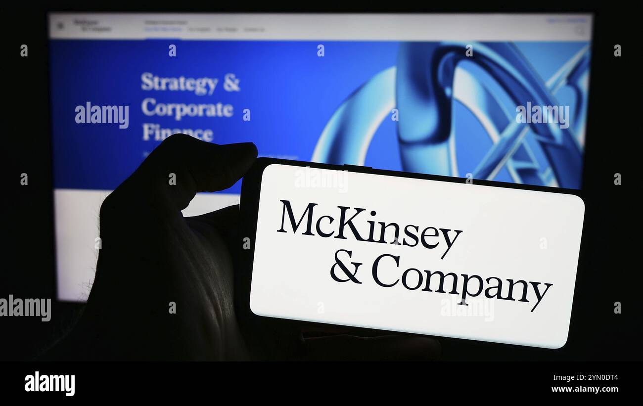 Stuttgart, Allemagne, 03-16-2024 : personne tenant un téléphone portable avec le logo de l'entreprise américaine de conseil McKinsey and Company devant la page Web. Mise au point Banque D'Images