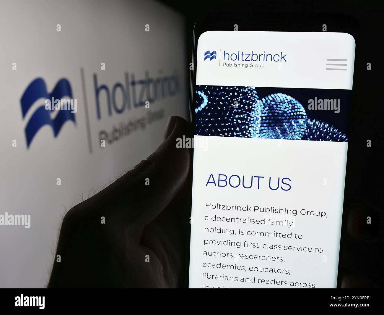 Stuttgart, Allemagne, 05-22-2024 : personne tenant un smartphone avec le site web de la société de médias allemande Holtzbrinck Publishing Group devant le logo. Concentrez-vous sur Banque D'Images