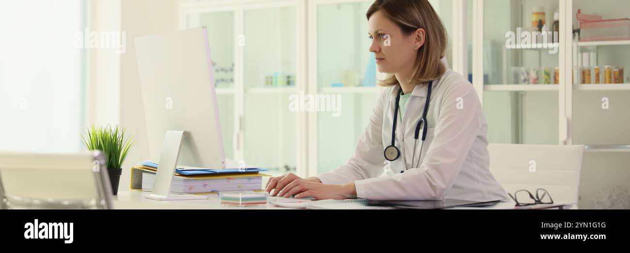 Le travailleur dans le domaine de la médecine saisit les données patient sur ordinateur Banque D'Images