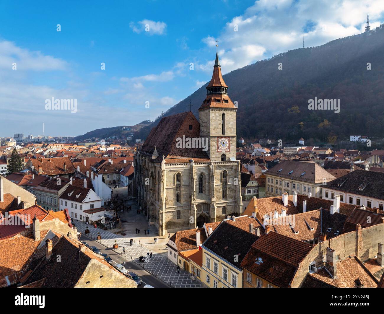 Vue aérienne de drone de l'église noire dans le vieux centre-ville de Brasov en saison d'automne. Montagnes et ciel bleu avec nuages. Roumanie Banque D'Images
