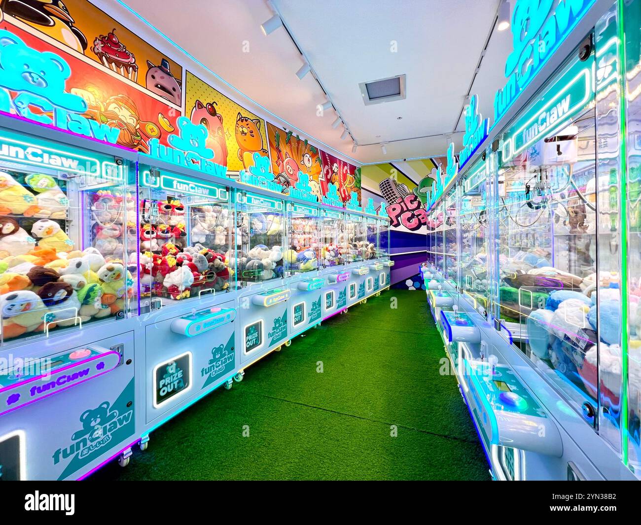 Machinese à griffes bien éclairées rempli de beaucoup de peluche pour les utilisateurs de faire l'expérience du jeu d'arcade. Singapour. Banque D'Images