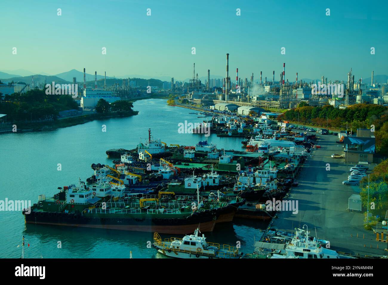 Ulsan, Corée du Sud - 14 novembre 2024 : une vue panoramique du port de Jangsaengpo, mettant en vedette les navires amarrés le long de la voie navigable avec les imposantes cheminées Banque D'Images