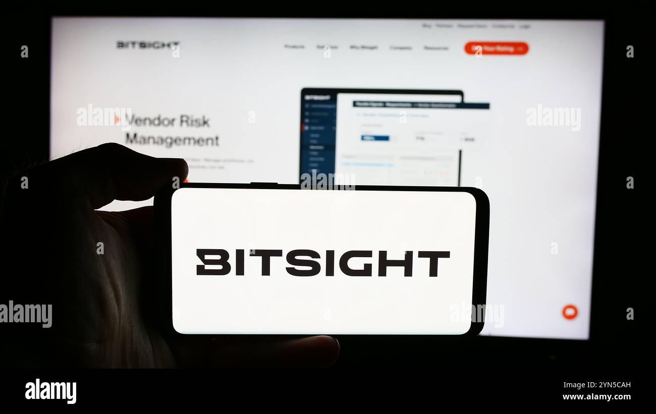 Dans cette illustration photo, une personne tient un téléphone portable avec le logo de la société américaine de notation de cybersécurité BitSight technologies Inc en face de la page Web. Banque D'Images