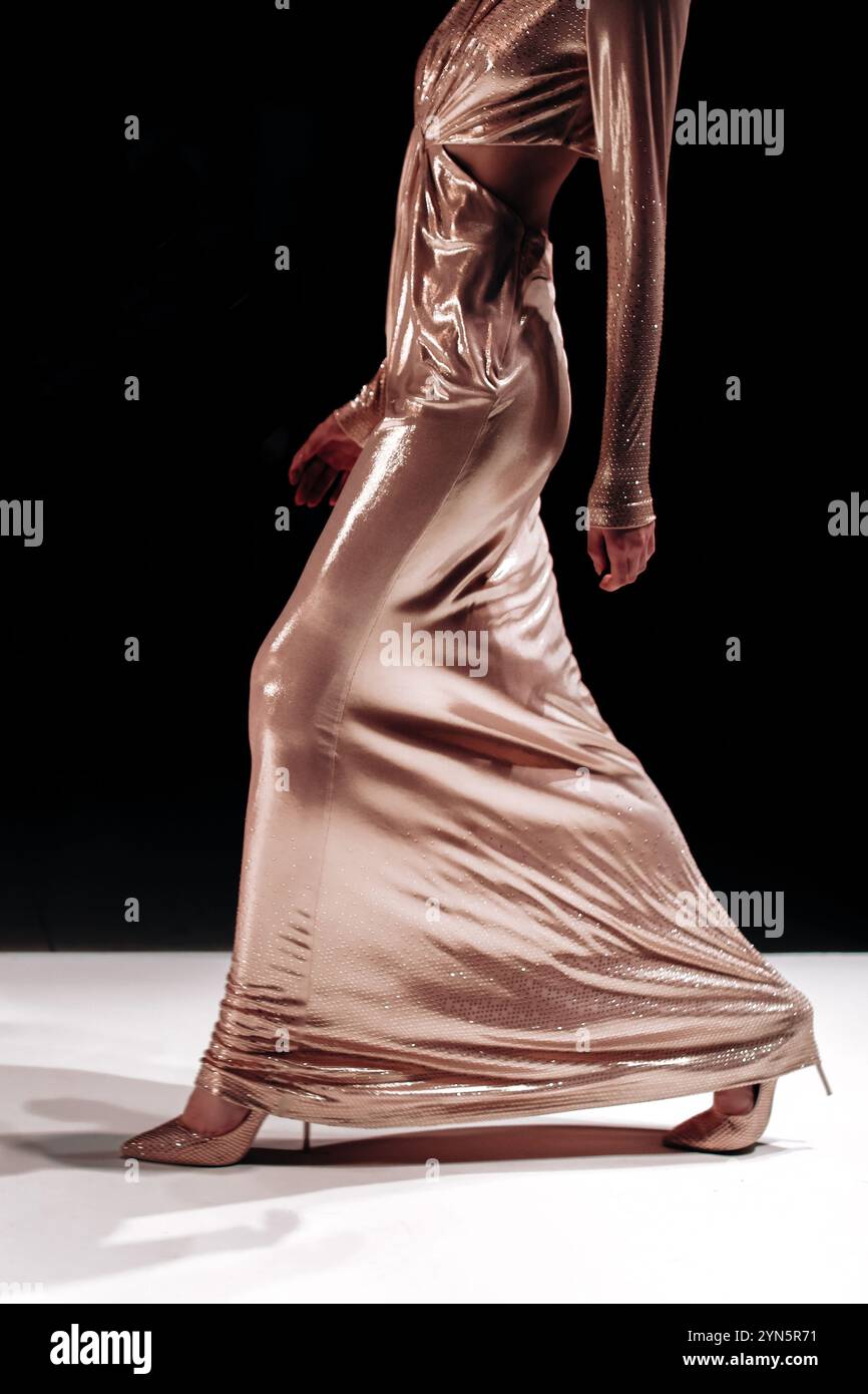 Longue robe dorée scintillante et talons hauts pour célébrer les vacances, mannequin marchant le défilé de mode Runway Banque D'Images