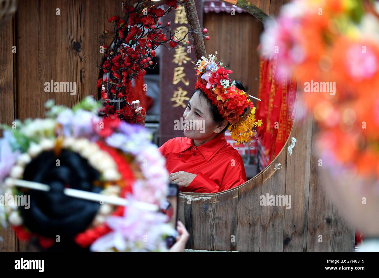 Quanzhou, China.21th novembre 2024. Les touristes portant des « enclos de fleurs en épingle à cheveux » prennent des photos dans le village de Xunpu. Xunpu Village est situé sur la rive nord du port de Quanzhou, le point de départ de l'ancienne route maritime de la soie. Il était autrefois le point de départ d'innombrables navires marchands océaniques et a une histoire de près de mille ans. Il est situé dans la ville de Quanzhou, province du Fujian, le 21 novembre 2024. Crédit : LV Ming/China News Service/Alamy Live News Banque D'Images