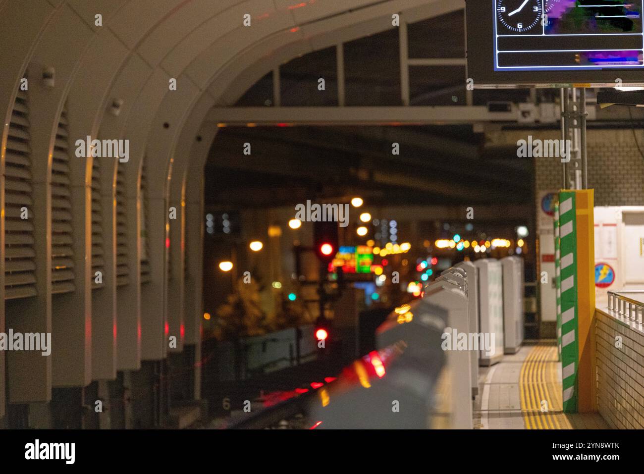 Station de métro urbaine la nuit avec lumières de ville floues Banque D'Images