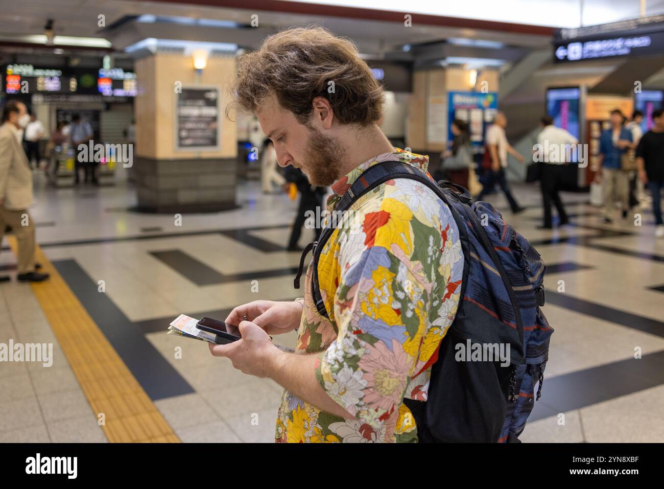 Touriste vérifier les indications d'accès dans une gare japonaise très fréquentée Banque D'Images