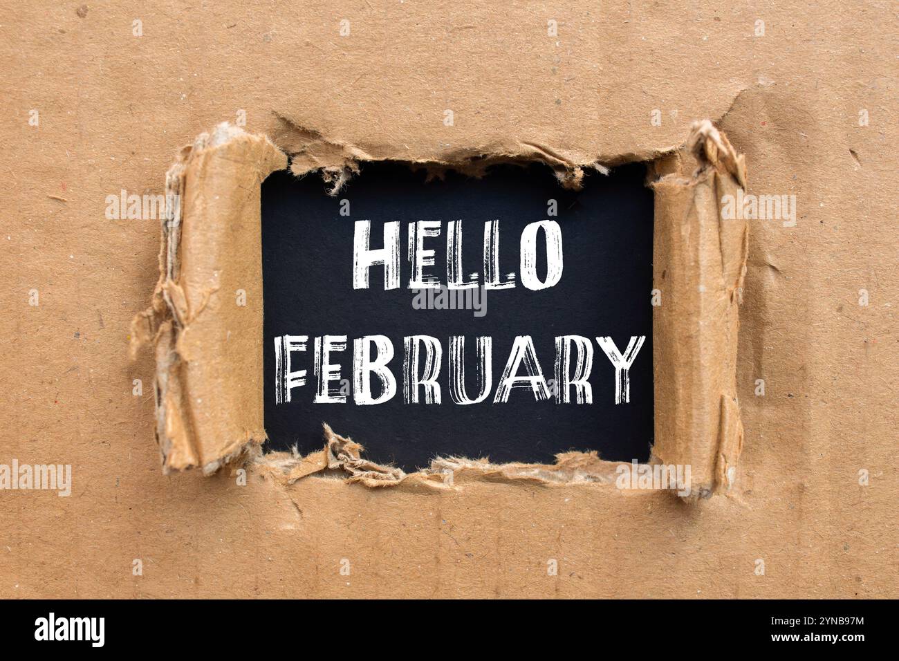 Bonjour février message écrit sur papier carton déchiré déchiré avec fond noir. Symbole conceptuel bonjour février. Copier l'espace. Banque D'Images