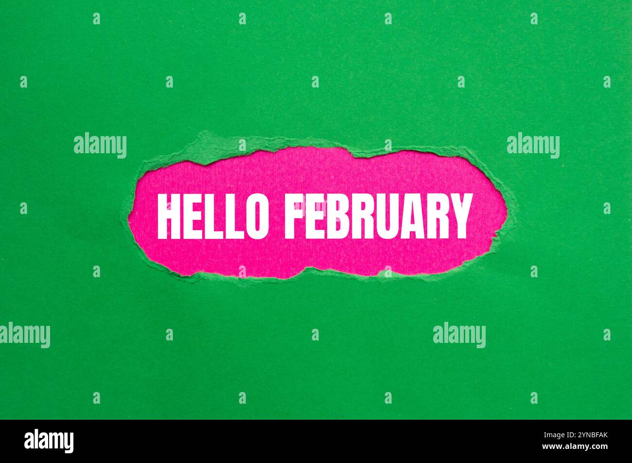 Bonjour février message écrit sur papier vert déchiré déchiré avec fond rose. Symbole conceptuel bonjour février. Copier l'espace. Banque D'Images